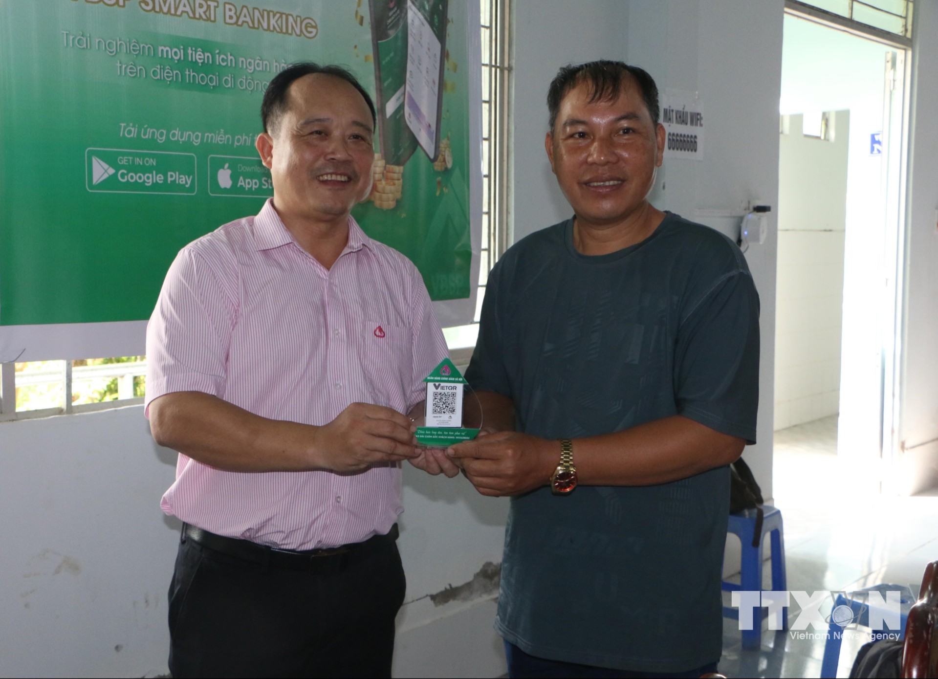Ông Nguyễn Văn Vũ, Giám đốc Phòng giao dịch Ngân hàng Chính sách xã hội Châu Thành A trao mã thanh toán QR cho cơ sở kinh doanh nhỏ lẻ trên địa bàn xã Tân Hòa, thành phố Cần Thơ. Ảnh: Duy Khương/TTXVN)